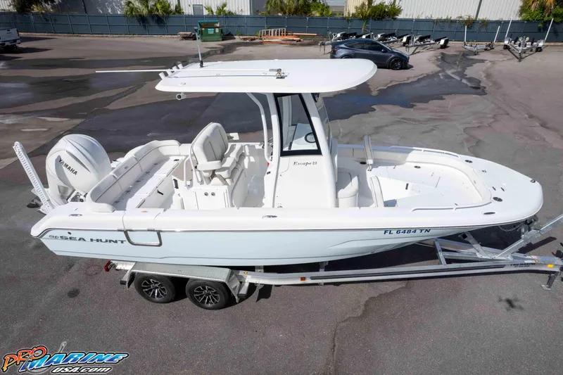 Slide: The Image of 2023 Sea Hunt Escape 23 boat on trailer, featuring Yamaha engine, parked outdoors. - 13