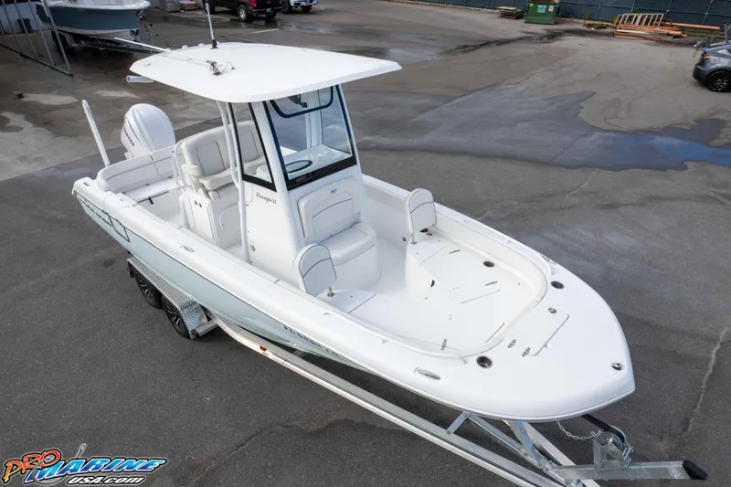 Slide: The Image of 2023 Sea Hunt Escape 23 boat on trailer, white exterior, parked in a lot. - 15
