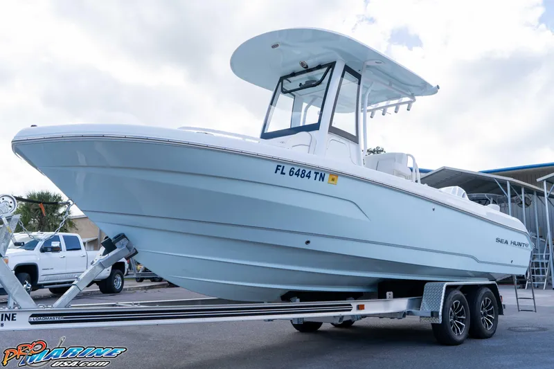 Slide: The Image of 2023 Sea Hunt Escape 23 boat on trailer, side view, parked outdoors. - 18