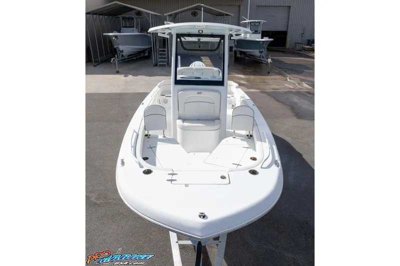 Slide: The Image of 2023 Sea Hunt Escape 23 boat, white exterior, docked at a marina. - 19