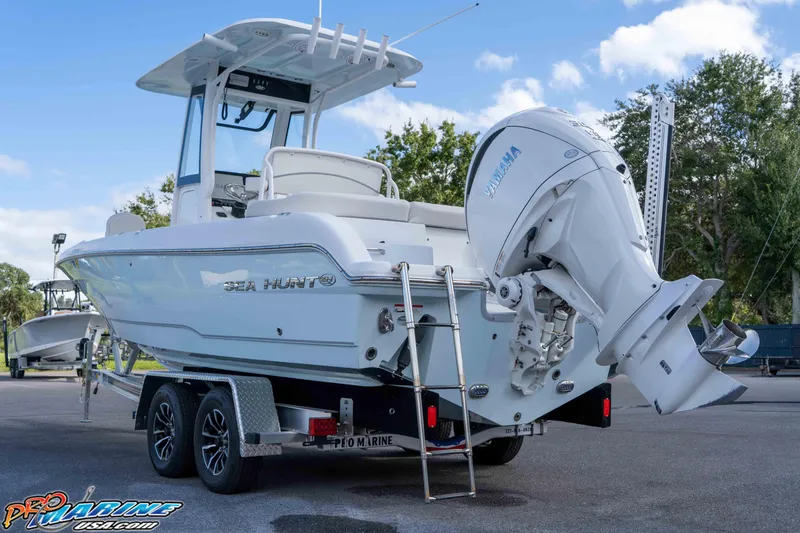 Slide: The Image of 2023 Sea Hunt Escape 23 boat with Yamaha engine on trailer, outdoor setting. - 26