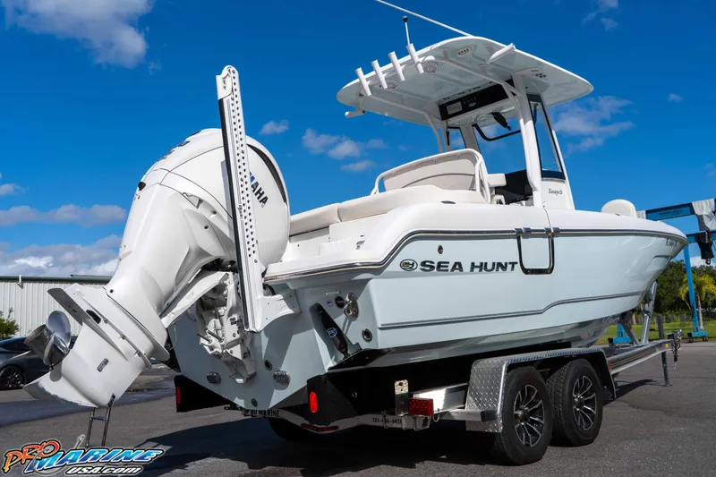 Slide: The Image of 2023 Sea Hunt Escape 23 boat on trailer, featuring Yamaha engine, under clear blue sky. - 29