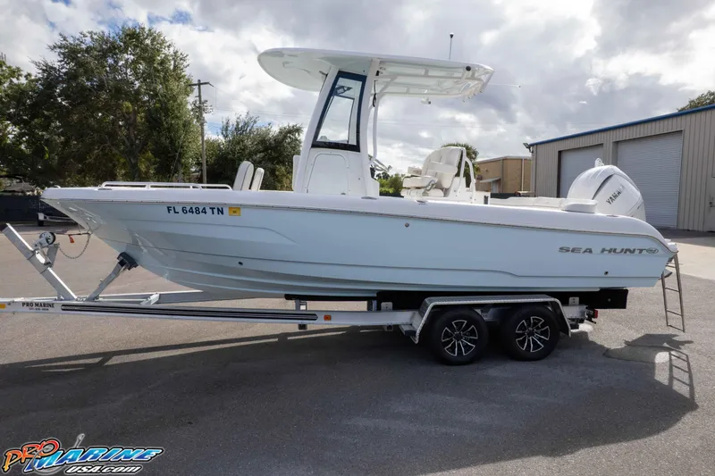 Slide: The Image of 2023 Sea Hunt Escape 23 boat on trailer, parked outdoors under cloudy sky. - 4