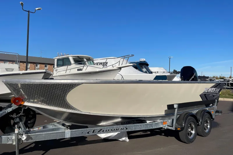 The Image of 2026 Hewescraft 200 Pioneer boat on trailer, displayed outdoors under clear blue sky. - 0