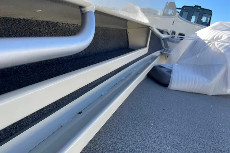 Slide: The Image of 2026 Hewescraft 200 Pioneer boat interior detail with metal railing and protective covering. - 11