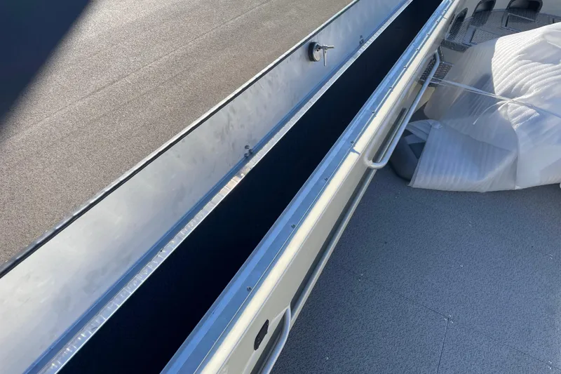 Slide: The Image of 2026 Hewescraft 200 Pioneer boat deck with storage compartment and protective cover. - 12