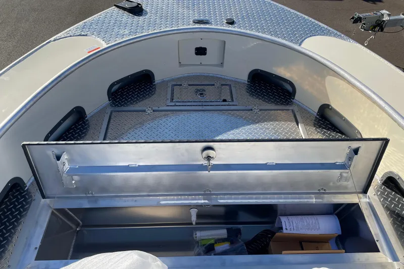 Slide: The Image of 2026 Hewescraft 200 Pioneer boat interior with open storage compartment and diamond plate flooring. - 19