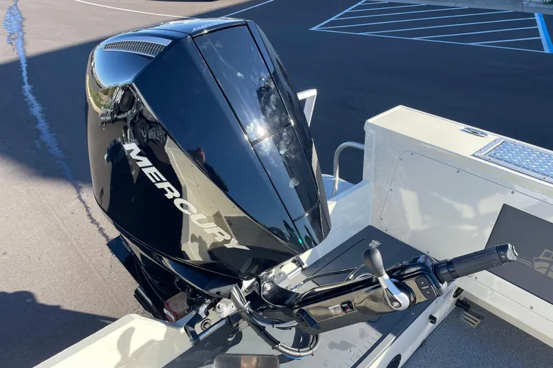 Slide: The Image of 2026 Hewescraft 200 Pioneer with Mercury outboard motor, parked on asphalt. - 7