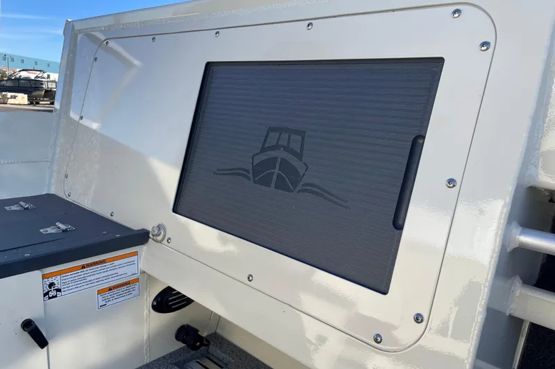 Slide: The Image of 2026 Hewescraft 200 Pioneer boat detail with storage compartment and warning label. - 8