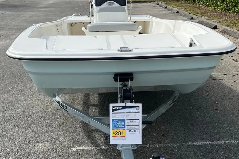 Slide: The Image of 2026 Mako Pro Skiff 17 CC boat on trailer, displayed in a parking lot. - 2