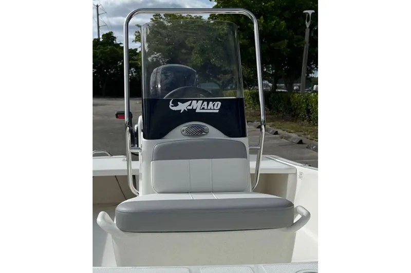 Slide: The Image of 2026 Mako Pro Skiff 17 CC boat with console and seating, parked outdoors. - 6
