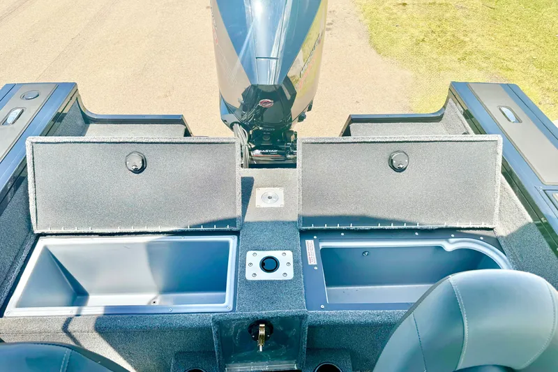Slide: The Image of 2026 Tracker Targa V-19 WT boat interior with open storage compartments and motor. - 14