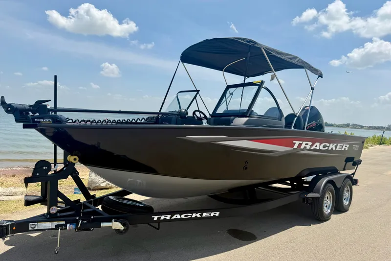 Slide: The Image of 2026 Tracker Targa V-19 WT boat on trailer by lakeside under blue sky. - 16