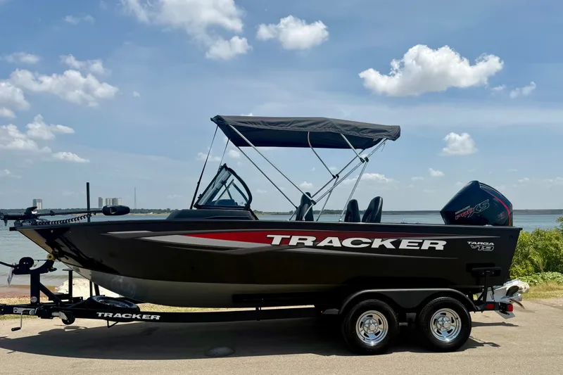 Slide: The Image of 2026 Tracker Targa V-19 WT boat on trailer by a lake under a blue sky. - 17