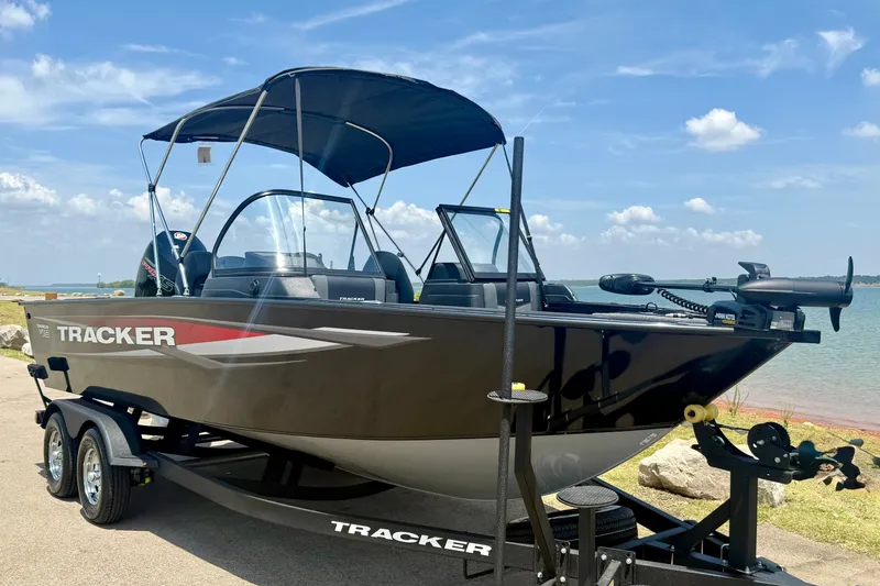 Slide: The Image of 2026 Tracker Targa V-19 WT boat on trailer by a lake under a clear sky. - 7