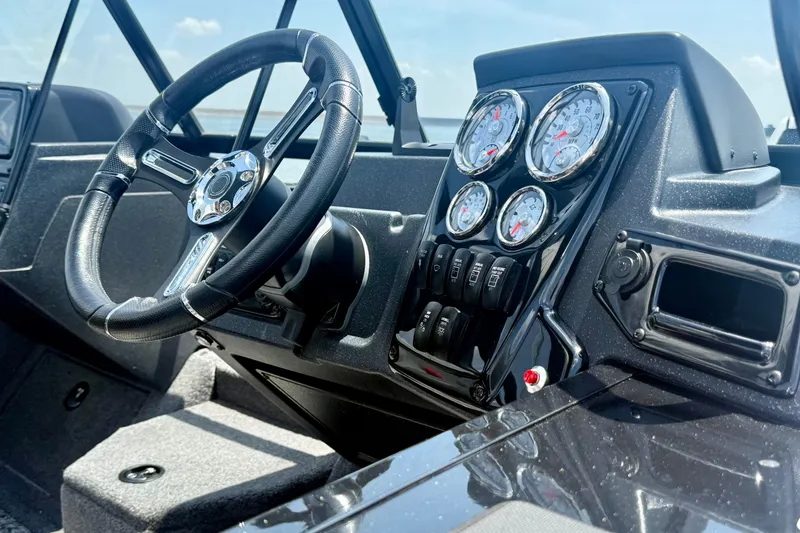 Slide: The Image of 2026 Tracker Targa V-19 WT boat dashboard with steering wheel and gauges. - 5
