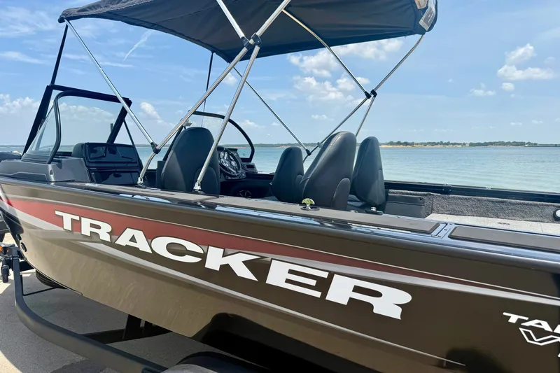 Slide: The Image of 2026 Tracker Targa V-19 WT boat by the water, featuring sleek design and canopy. - 19