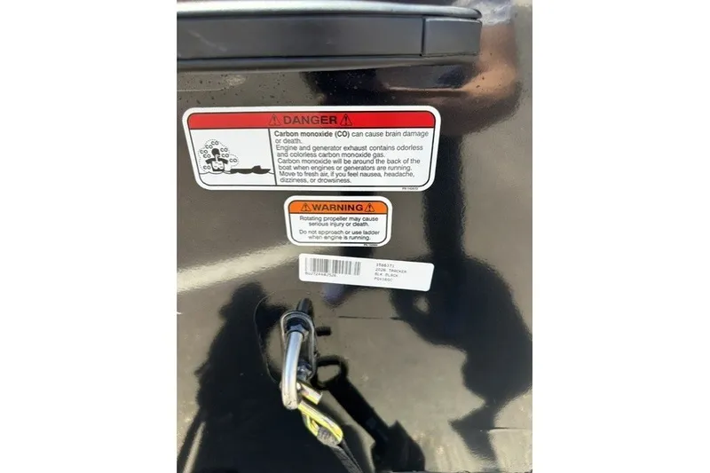 Slide: The Image of Warning labels on a 2026 Tracker Pro Guide V-16 SC boat, highlighting carbon monoxide and propeller hazards. - 59