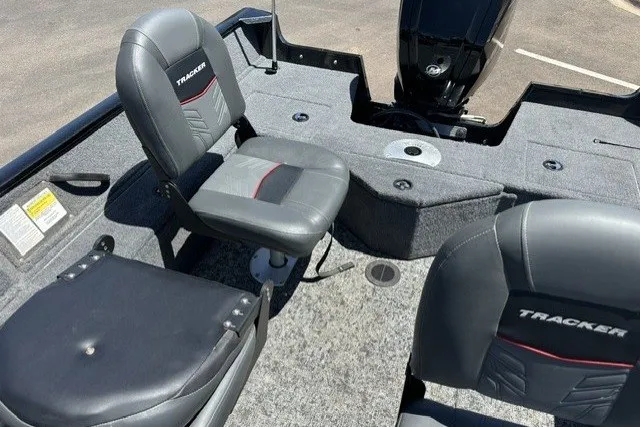 Slide: The Image of 2026 Tracker Pro Guide V-16 SC boat interior with seating and motor, featuring gray upholstery. - 13