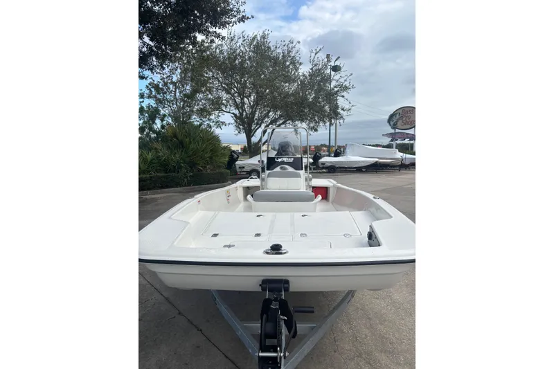 Slide: The Image of 2026 Mako Pro Skiff 15 CC boat on trailer, parked outdoors. - 1