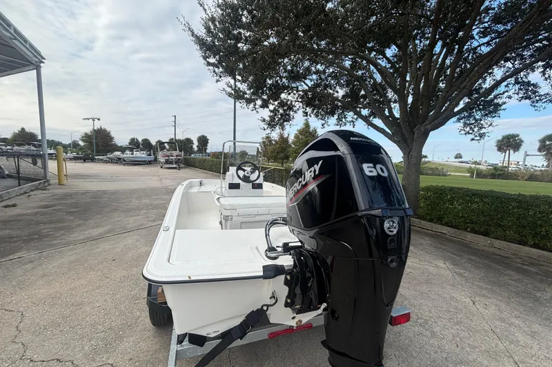 Slide: The Image of 2026 Mako Pro Skiff 15 CC with Mercury 60 engine, parked outdoors. - 2