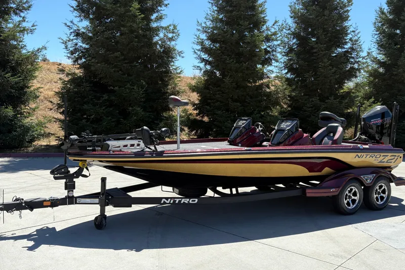 Slide: The Image of 2026 Nitro Z21 XL Pro bass boat on trailer, parked outdoors. - 4