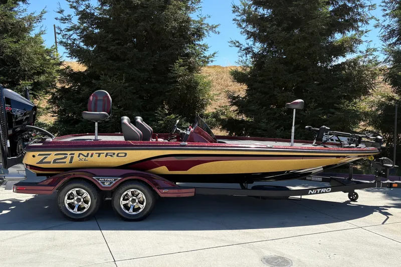 The Image of 2026 Nitro Z21 XL Pro bass boat on trailer, parked outdoors. - 0