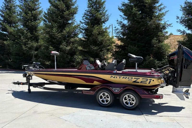 Slide: The Image of 2026 Nitro Z21 XL Pro boat on trailer, parked outdoors with trees in background. - 6