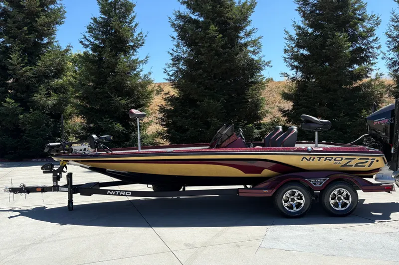 Slide: The Image of 2026 Nitro Z21 XL Pro bass boat on trailer, parked outdoors. - 1