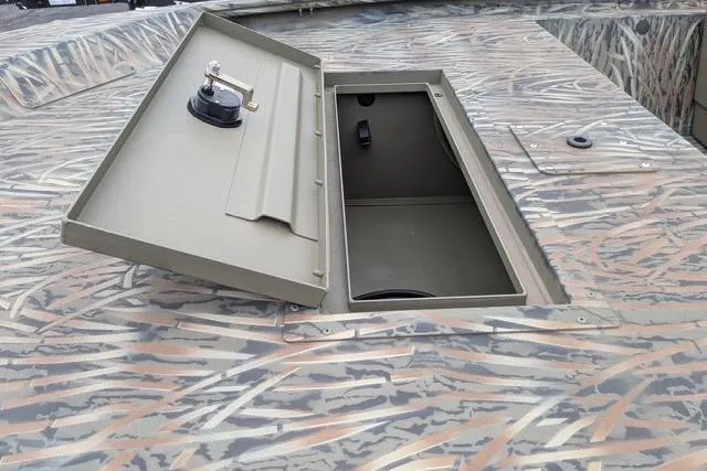 Slide: The Image of Open storage compartment on 2026 Tracker Grizzly 1648 SC boat with camouflage pattern. - 5