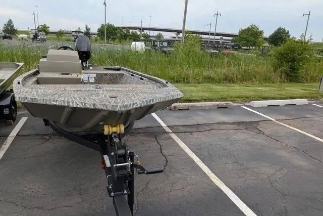 Slide: The Image of 2026 Tracker Grizzly 1648 SC boat parked in a lot, featuring a camouflage design. - 8
