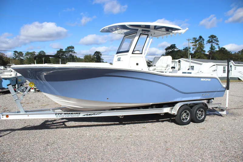 Slide: The Image of 2026 Sea Fox 248 Commander boat on trailer, blue hull, parked outdoors. - 2