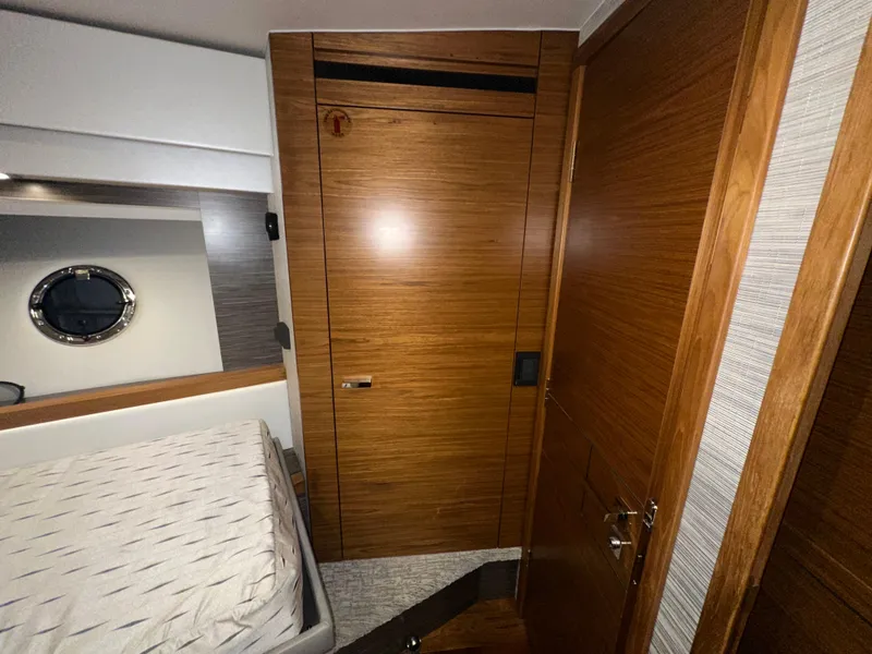 Slide: The Image of 2020 Tiara Yachts F53 Flybridge cabin interior with wooden doors and bed. - 22