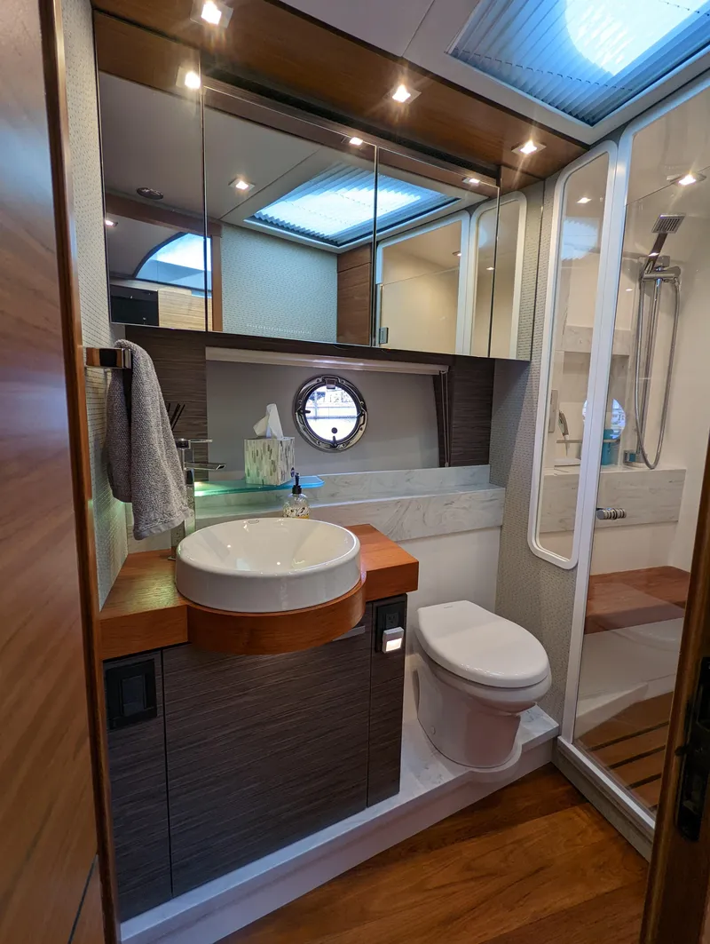 Slide: The Image of Luxurious bathroom in 2020 Tiara Yachts F53 Flybridge with modern fixtures and wood accents. - 23
