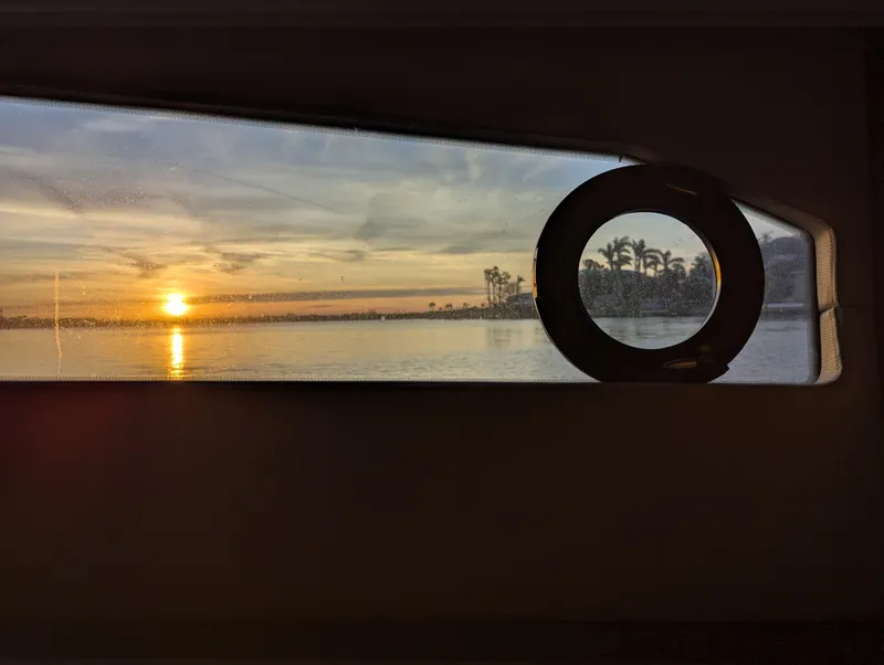 Slide: The Image of Sunset view through Tiara Yachts F53 Flybridge window, 2020 model, with palm trees silhouette. - 34