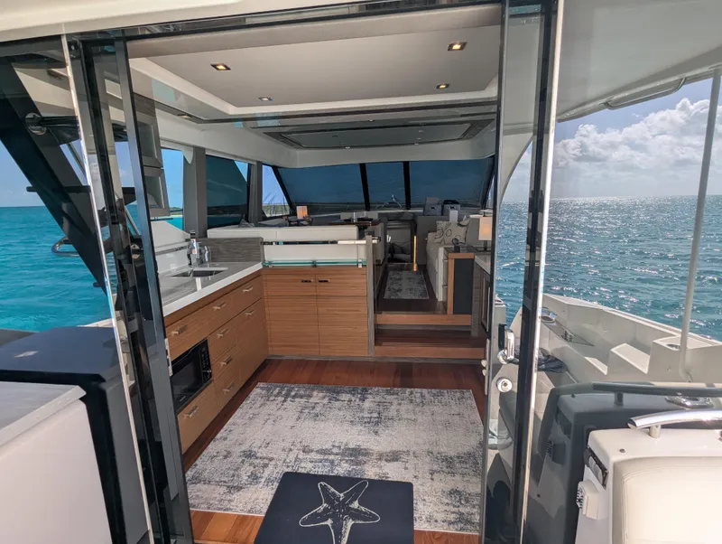Slide: The Image of Interior of 2020 Tiara Yachts F53 Flybridge with ocean view through glass doors. - 36