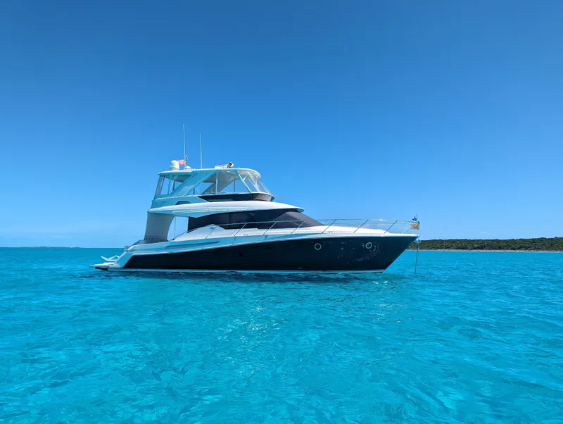 Slide: The Image of 2020 Tiara Yachts F53 Flybridge on clear blue water under a bright sky. - 4