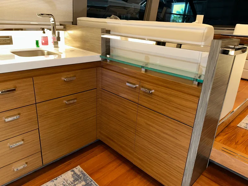 Slide: The Image of Modern kitchen interior on 2020 Tiara Yachts F53 Flybridge, featuring sleek wood cabinetry and countertops. - 40