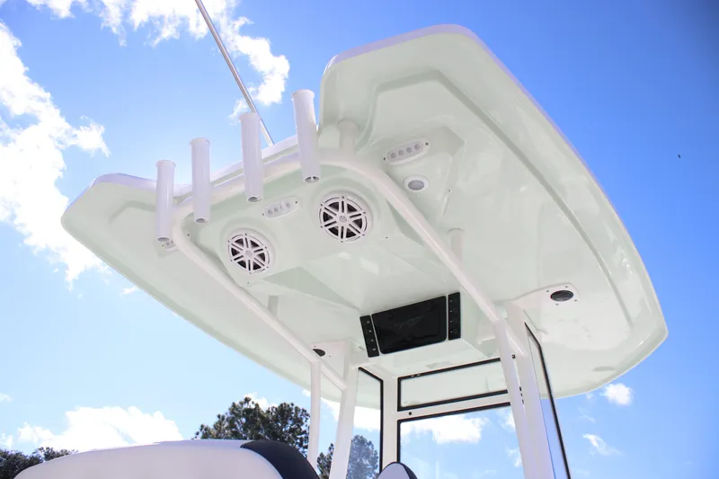 Slide: The Image of 2026 Tidewater 220 LXF boat's T-top with speakers and rod holders against blue sky. - 15