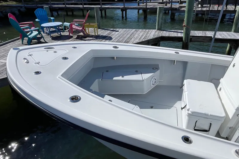 Slide: The Image of 2023 Pair Customs 24 Center Console DV boat docked with colorful chairs nearby. - 12