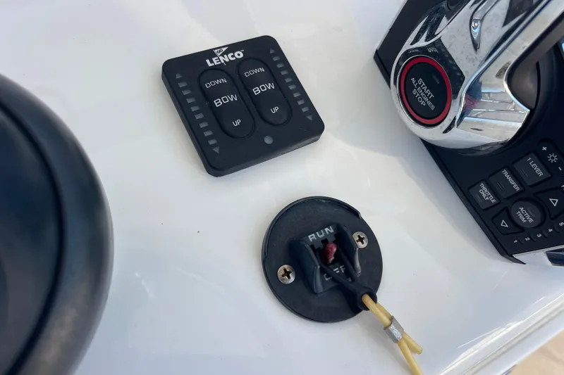 Slide: The Image of Control panel of 2023 Pair Customs 24 Center Console DV boat, featuring Lenco trim tab switches. - 20