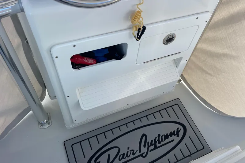 Slide: The Image of 2023 Pair Customs 24 Center Console DV boat interior with storage compartments and branded mat. - 21