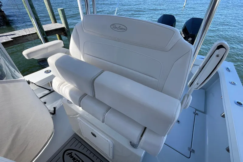 Slide: The Image of 2023 Pair Customs 24 Center Console DV boat with white seating, docked by the water. - 22