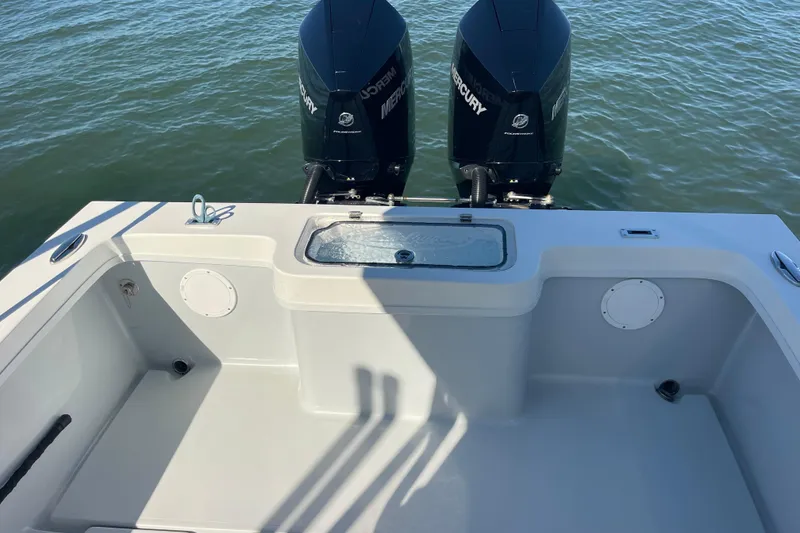 Slide: The Image of 2023 Pair Customs 24 Center Console DV with dual Mercury outboard engines on water. - 24