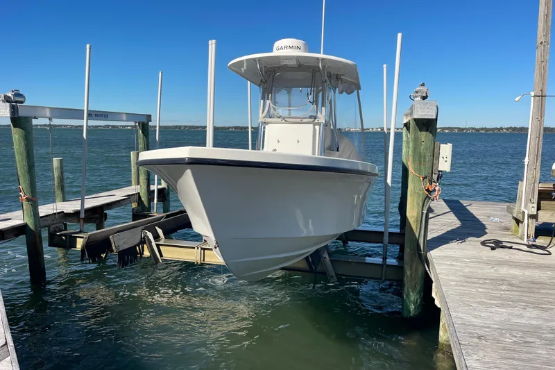 Slide: The Image of 2023 Pair Customs 24 Center Console DV boat docked on a lift by the water. - 41