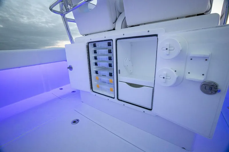 Slide: The Image of Manufacturer Provided Image: 2025 Southport 27 FE boat interior with storage compartments and ambient lighting. - 8