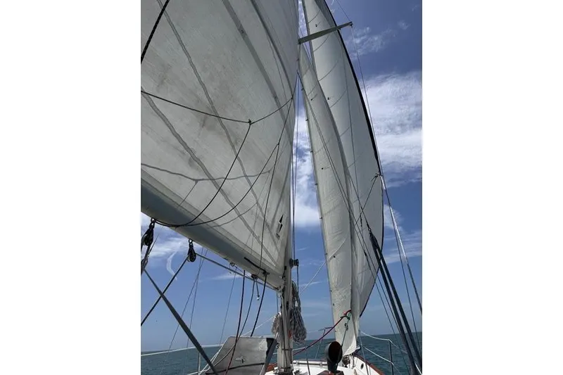 Slide: The Image of Sailing on a 1989 Pacific Seacraft Crealock under clear blue skies. - 11