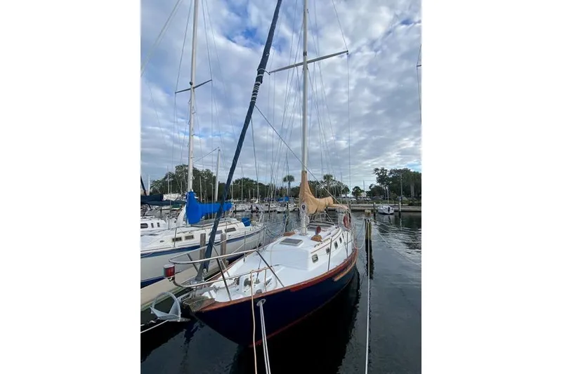 Slide: The Image of 1989 Pacific Seacraft Crealock sailboat docked in a marina under a cloudy sky. - 2