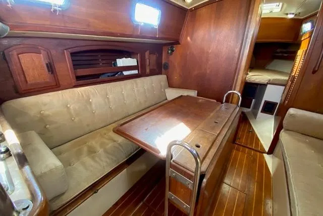 Slide: The Image of 1989 Pacific Seacraft Crealock yacht interior with wooden finishes and cozy seating area. - 24