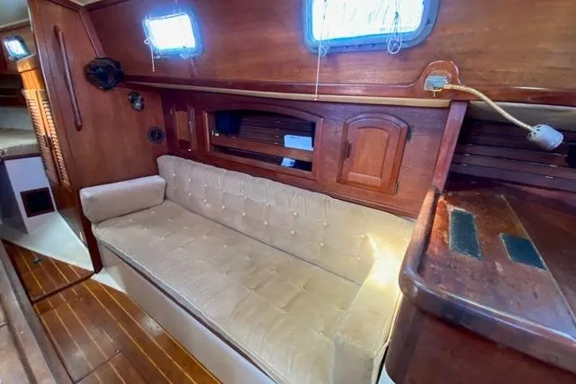 Slide: The Image of 1989 Pacific Seacraft Crealock interior with wooden finish and beige cushioned seating. - 25